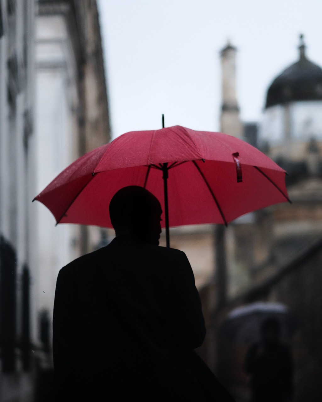 Passant mit rotem Regenschirm