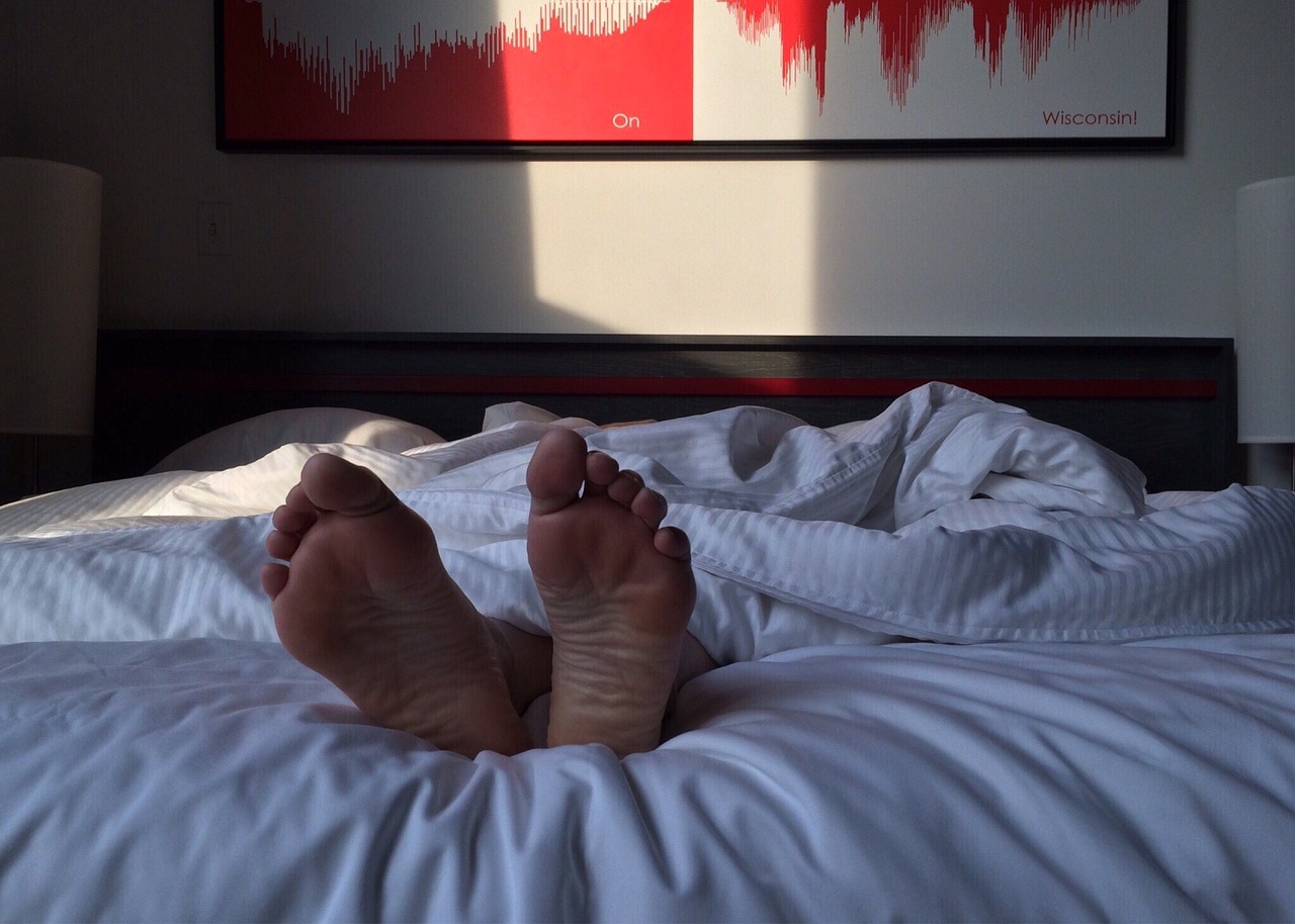 Fuße gucken unter der Bettdecke hervor